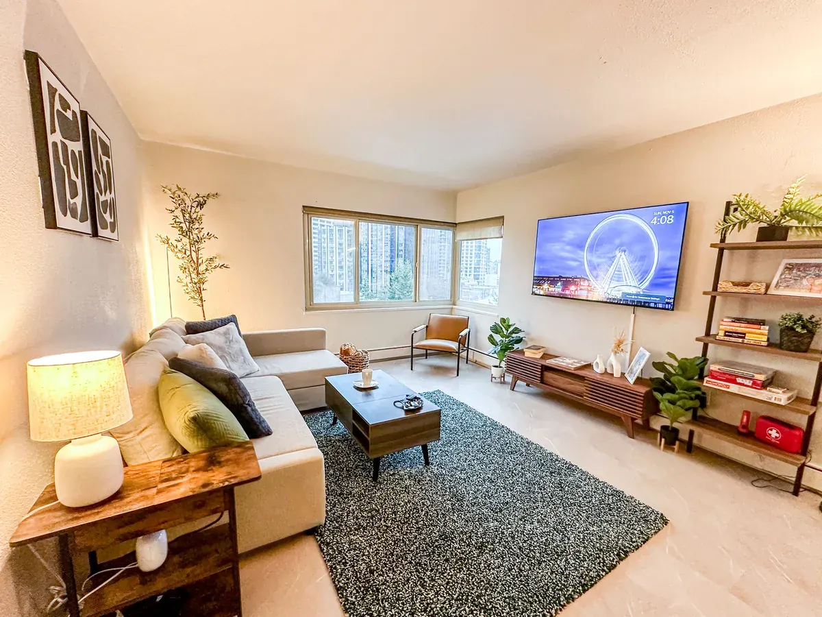 Living room with rug, sofa and wall-mounted TV