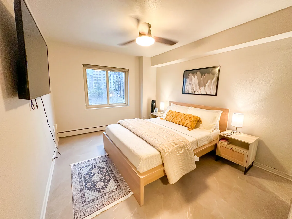 Queen bedroom with a ceiling fan and window
