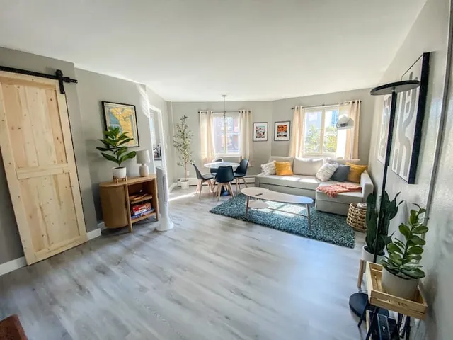 Wide living space with wood floors and barn door