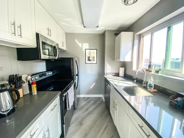 Kitchen with white cabinets and window