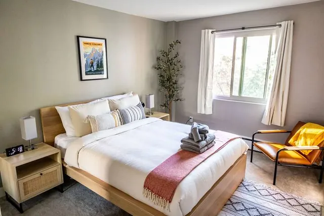 Queen bedroom with window and chair