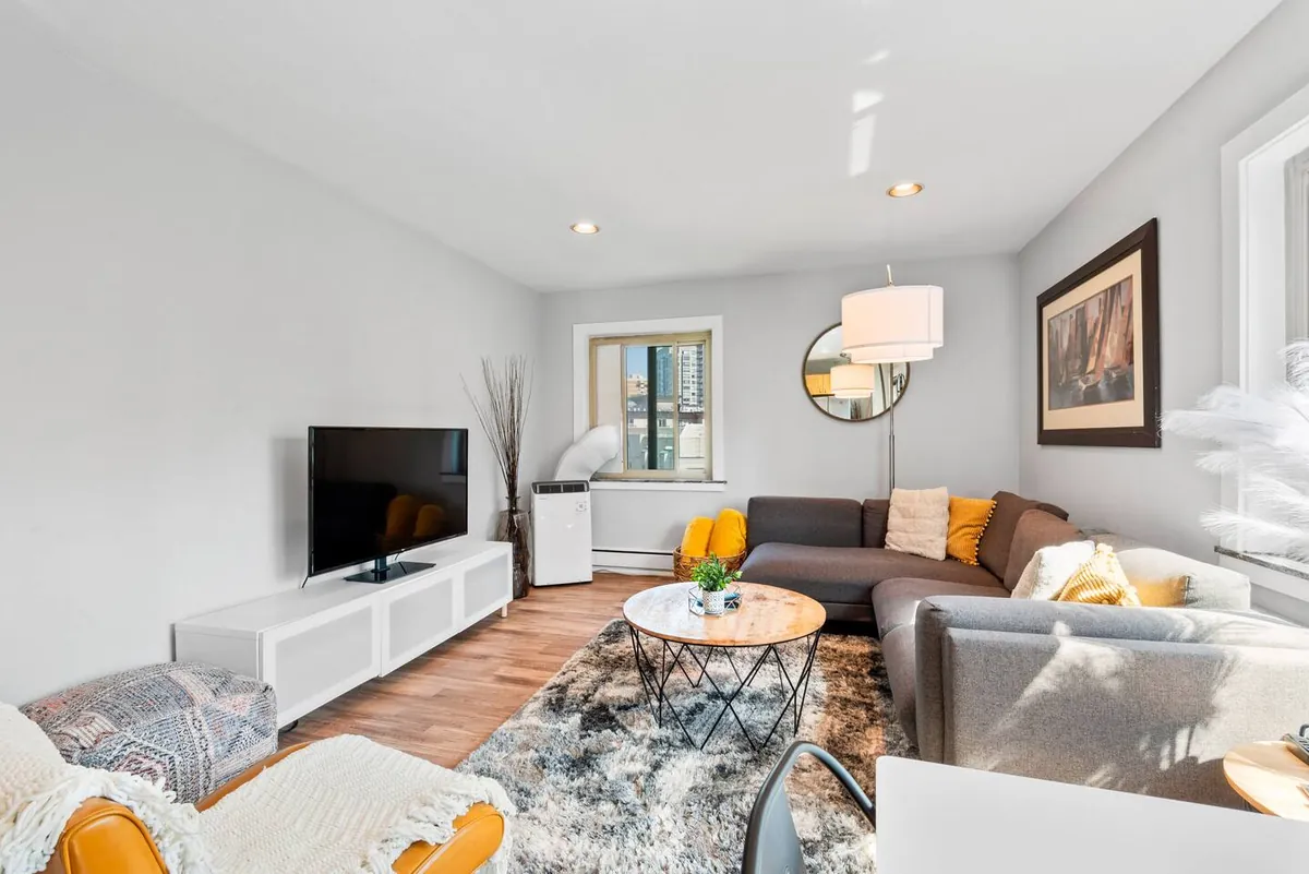 Living area with sofa, TV and rug